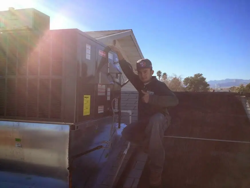 HVAC technician performing HVAC Inspection on a rooftop unit in Guttenberg